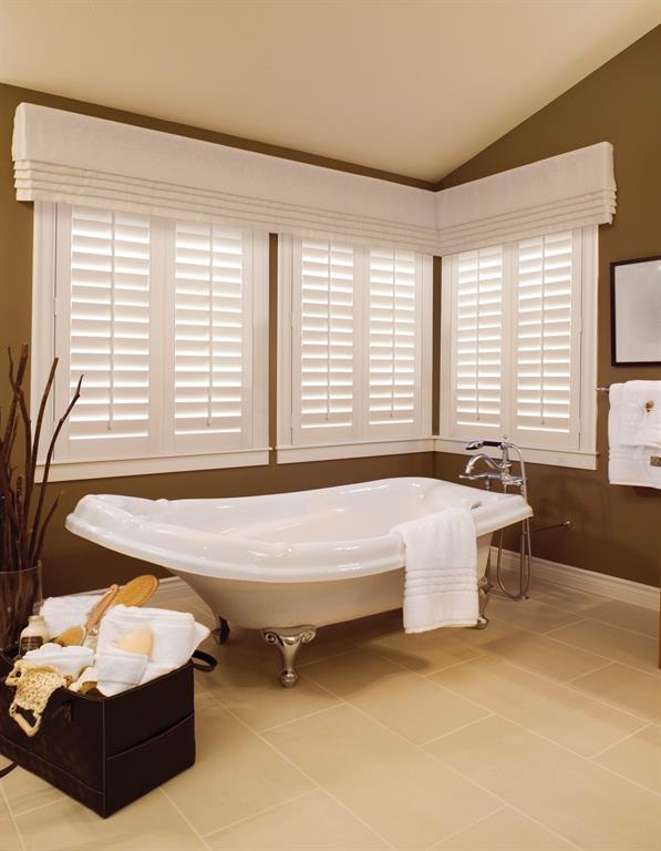 White plantation shutters give a crisp look to a brown bathroom